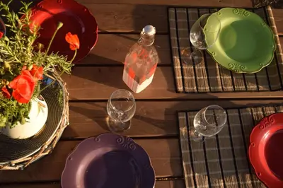 a table with plates and glasses and a vase of flowers at Cedrus and Sea, beachfront house, Gennadi, Rhodes in Gennadi