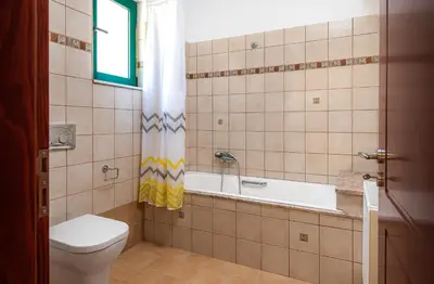 a bathroom with a tub and a toilet and a sink at Anemos Villa in Sálakos