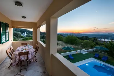 a view from the balcony of a villa with a table and a pool at Anemos Villa in Sálakos