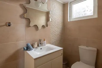 a bathroom with a sink and a toilet and a mirror at IL PARADISO DI MICHAIL in Phanaes