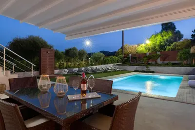 a dining table with chairs and a swimming pool at IL PARADISO DI MICHAIL in Phanaes