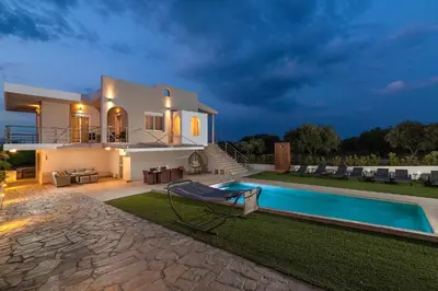 a villa with a swimming pool at night at IL PARADISO DI MICHAIL in Phanaes