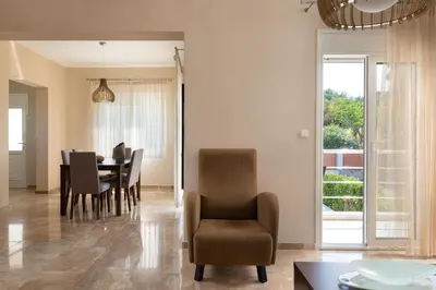 a dining room and living room with a table and chairs at IL PARADISO DI MICHAIL in Phanaes