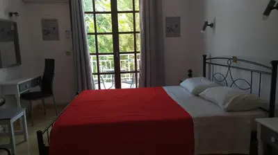 a bedroom with a bed and a desk and a window at Nitsas studio's in Kremasti