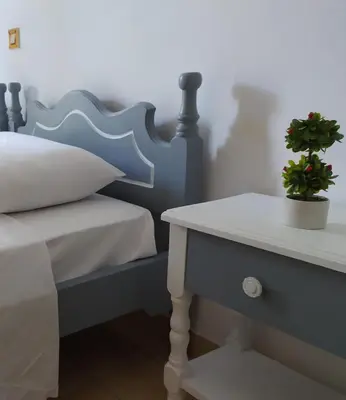a bedroom with a bed and a table with a potted plant at Nitsas studio's in Kremasti