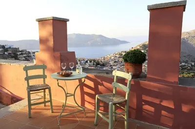 a table and two chairs on a balcony with a view at Astradeni in Symi