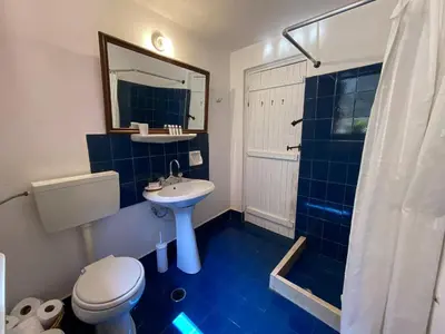 a blue bathroom with a toilet and a sink at Astradeni in Symi