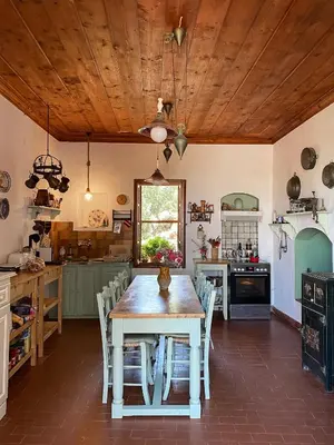 a kitchen with a wooden ceiling and a table and chairs at Astradeni in Symi