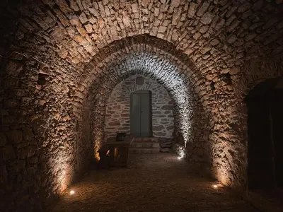 a dark hallway with a door in a brick tunnel at Astradeni in Symi