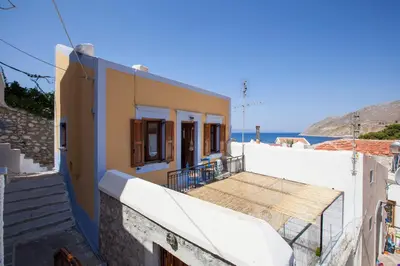 a house with stairs and a view of the ocean at Avra in Symi