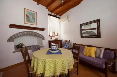 a dining room with a table and a couch at Avra in Symi