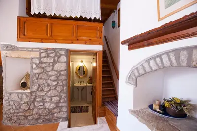 two images of a hallway with a stairway and a room at Avra in Symi