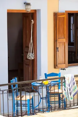 a table and chairs in a room with a door at Avra in Symi