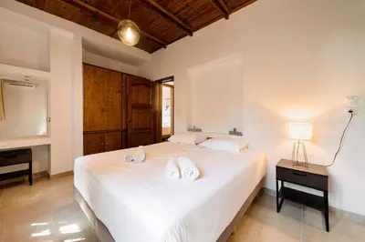 a bedroom with a white bed with two towels on it at Ariadni Villas Faliraki in Faliraki
