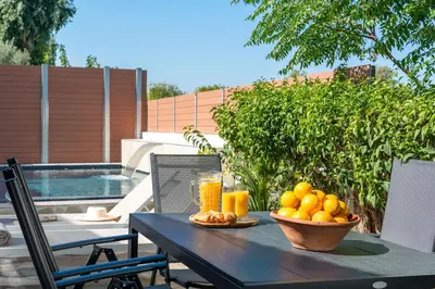 a table with a bowl of fruit and a glass of orange juice at Ariadni Villas Faliraki in Faliraki