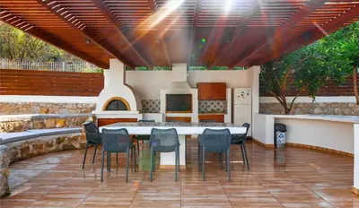 a patio with a table and chairs and a kitchen at Bella Foresta Villa II in Rhodes Town