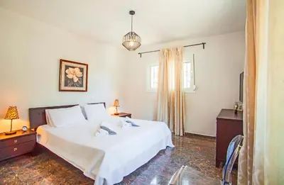 a bedroom with a white bed and a window at Bella Foresta Villa II in Rhodes Town