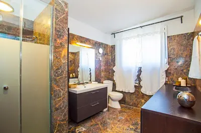 a bathroom with a sink and a toilet and a mirror at Bella Foresta Villa II in Rhodes Town
