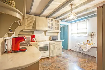 a kitchen with white cabinets and a red appliance at Bella Foresta Villa II in Rhodes Town