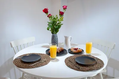 a white table with two plates of food and orange juice at ELiteDIMension in Rhodes Town