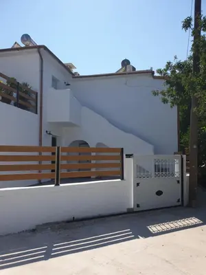 a white house with a gate and a fence at ELiteDIMension in Rhodes Town