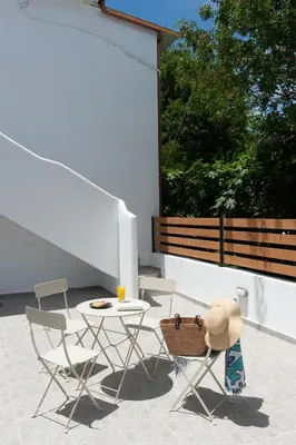 a patio with a table and chairs and a window at ELiteDIMension in Rhodes Town