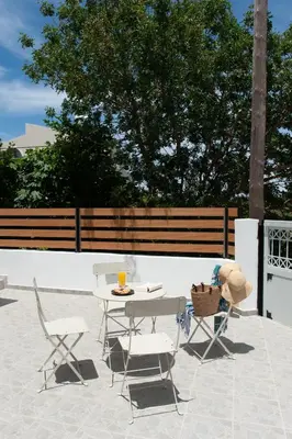 a patio with a table and two chairs and a table with a hat at ELiteDIMension in Rhodes Town