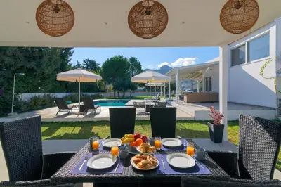 a table with a plate of food on top of a patio at Casa Bianca Villa in Kolimbia