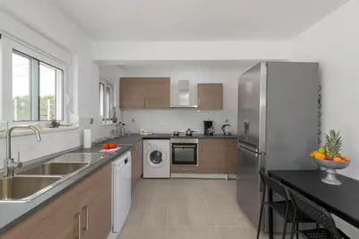 a kitchen with a sink and a refrigerator at Casa Bianca Villa in Kolimbia