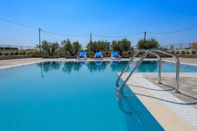 a swimming pool with a slide in the water at Villa Valasia in Gennadi