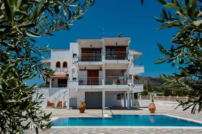 a building with a swimming pool in front of it at Villa Valasia in Gennadi
