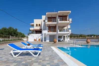 a villa with a swimming pool in front of a building at Villa Valasia in Gennadi