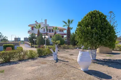a large white pot sitting in front of a house at Villa Valasia in Gennadi