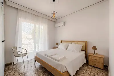 a bedroom with a bed and a chair and a window at Sunway Suite in Rhodes Town