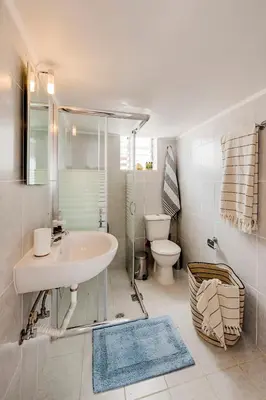 a white bathroom with a sink and a toilet at Sunway Suite in Rhodes Town