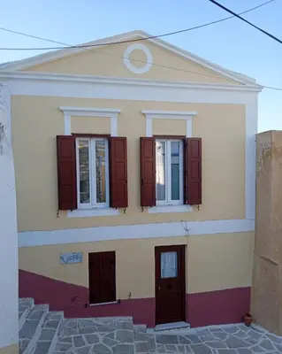 a house with red shutters on it at Marthas Traditional House in Symi