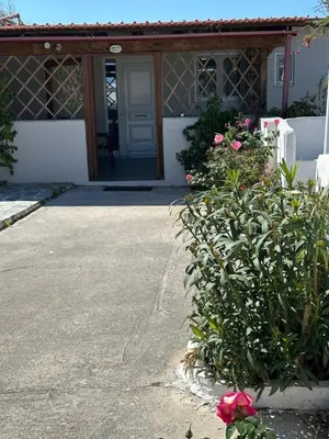 a house with a door and a bush with pink flowers at House of Paradise in front of the golf court-sea in Rhodes Town