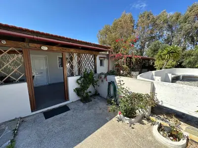 a house with a door and some plants at House of Paradise in front of the golf court-sea in Rhodes Town