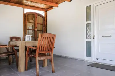 a dining room table with chairs and a white door at House of Paradise in front of the golf court-sea in Rhodes Town