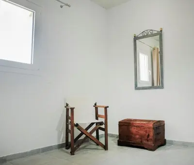 a mirror and a wooden chair and a wooden box at House of Paradise in front of the golf court-sea in Rhodes Town