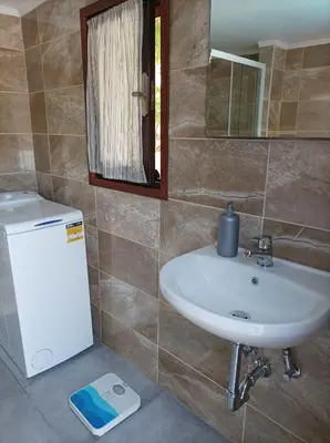 a bathroom with a sink and a small refrigerator at MA-GIA in Pastida