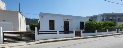 a white house with a fence on the side of a street at MA-GIA in Pastida