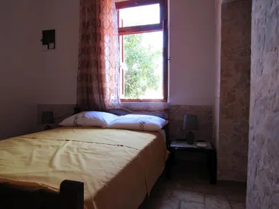 a bedroom with a bed and a window at Pitini Sevasti house in Symi