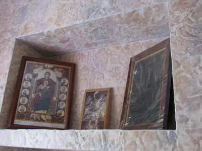 three framed pictures on a stone wall with paintings at Pitini Sevasti house in Symi
