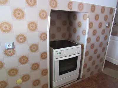 a small kitchen with a stove in the corner at Pitini Sevasti house in Symi