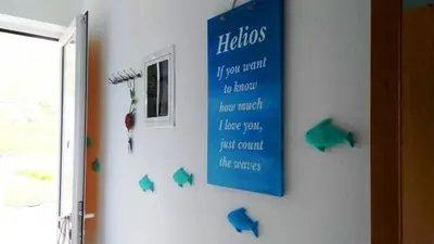a blue sign on a wall with green butterflies on it at Haraki Memories Beach Studios in Haraki