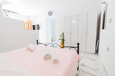 a white bedroom with a bed with towels on it at Villa Ioanna in Symi