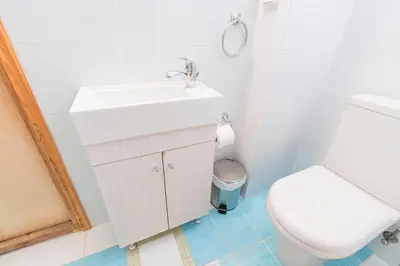 a bathroom with a white sink and a toilet at Villa Ioanna in Symi