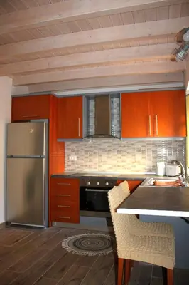 a kitchen with a stainless steel refrigerator and wooden cabinets at EVANNA HOUSE in Symi