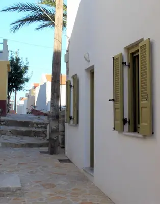 two open windows on a white building with a palm tree at EVANNA HOUSE in Symi